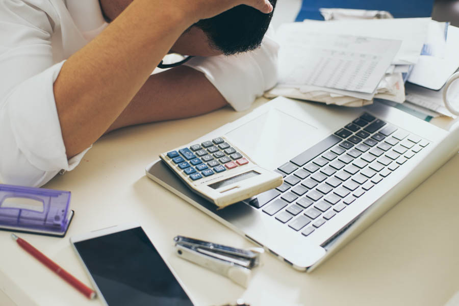 Man counting using a calculator to understand a home model and a cash deposit illustrating the loan-to-value rules